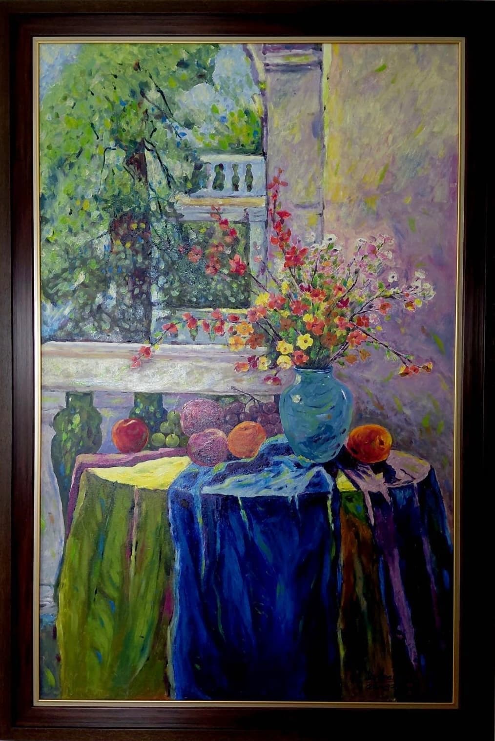 "ระเบียงยามบ่ายกับแจกันดอกไม้" ผลงานสีน้ำมันบนผ้าใบปี 2568 ขนาดรวมกรอบ 84 × 124 ซม. โดยบรรเลง ดำทองสุก จิตรกรไทยจบจิตรกรรมสากลจากเพาะช่างที่วาดงานได้หลากหลายทั้งเนื้อหาและเทคนิค เป็นภาพโต๊ะริมระเบียงที่คลุมด้วยผ้าหลายสีทั้งน้ำเงินเข้ม เขียวอมเหลือง และม่วง บนโต๊ะมีแจกันสีฟ้าอมเขียวใส่ช่อดอกไม้ป่าสีแดง เหลือง ชมพู และขาวที่แผ่กิ่งก้านออกไปอย่างอิสระ รายล้อมด้วยแอปเปิลแดง ส้ม ทับทิม องุ่น และผลไม้สีเขียว ด้านหลังเป็นราวระเบียงแบบคลาสสิก เสาปูน และต้นไม้ใหญ่เขียวชอุ่มที่ต้องแสงแดดยามบ่าย ฝีแปรงสั้นถี่และสีสันสดใสแบบอิมเพรสชันนิสม์ทำให้แสงดูระยิบระยับไปทั่วทั้งภาพ ถ่ายทอดความสงบและอบอุ่นของช่วงบ่ายที่ได้นั่งพักริมระเบียง ใส่กรอบไม้สีน้ำตาลเข้มขอบทองพร้อมแขวน เป็นภาพขนาดใหญ่ที่เหมาะกับห้องนั่งเล่น ห้องรับแขก หรือโถงทางเข้าที่ต้องการงานศิลปะเป็นจุดเด่นของพื้นที่